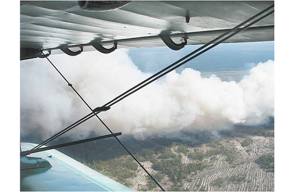 вид на лесной пожар с крыла самолета